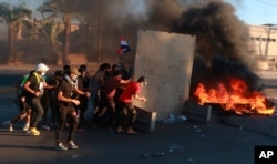 Anti-government protesters set fires and block a street during a demonstration in Baghdad, Oct. 4, 2019. Security forces opened fire on hundreds of anti-government demonstrators in central Baghdad, killing many protesters and injuring dozens.