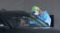 A healthcare worker takes a swab sample from a driver at a drive-through COVID-19 testing site, July 8, 2020, in Miami Gardens, Fla.