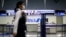 An employee, wearing protective mask following an outbreak of the coronavirus disease (COVID-19), passes in front of an All Nippon Airways (ANA) counter at the almost empty Kansai International Airport in Osaka, Japan, March 14, 2020. REUTERS/Edgard…
