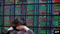 FILE - An investor monitors the stock market at a securities brokerage in Taipei.