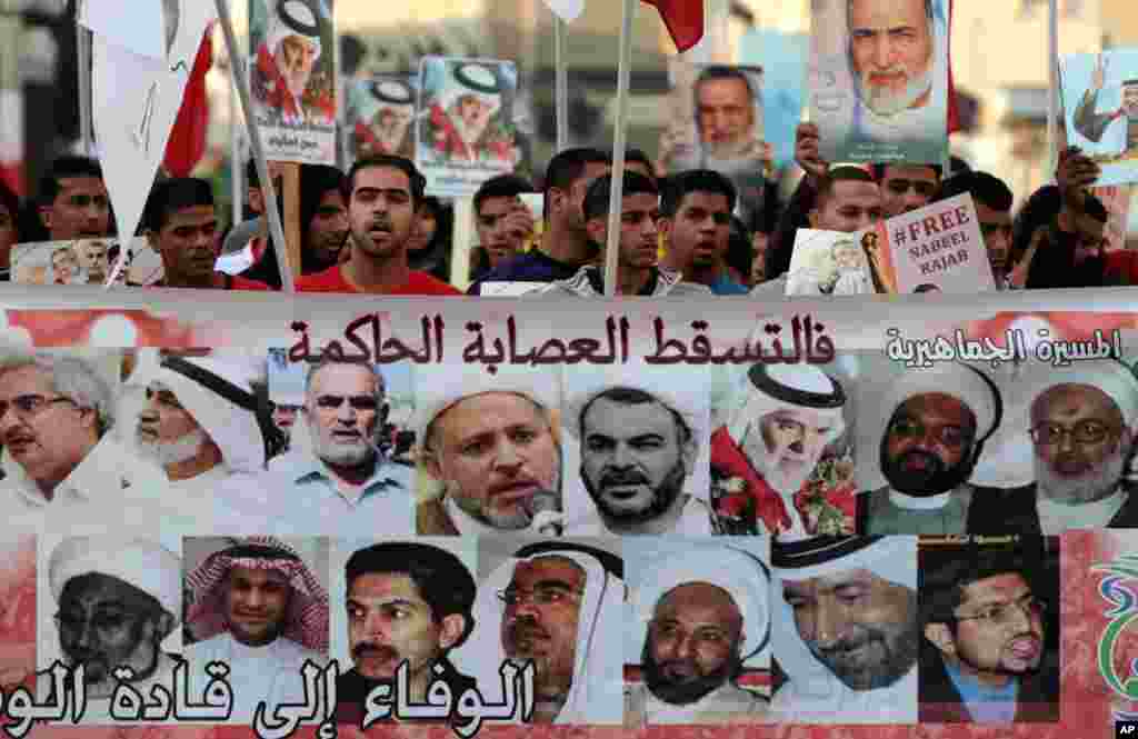 Anti-government protesters chant slogans as they hold banner and images of jailed opposition leaders in Malkiya village, Bahrain, January 7, 2013. 