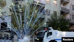 Riot police use water cannon as demonstrators throw fireworks during a protest against the curfew in Sur district, in the Kurdish dominated southeastern city of Diyarbakir, Turkey, December 8, 2015. 