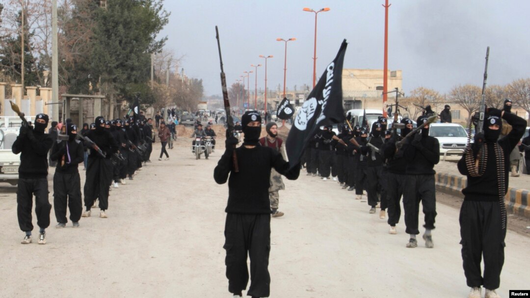 Fighters linked to al-Qaida carry their weapons during a parade at the Syrian town of Tel Abyad, near the border with Turkey, Jan. 2, 2014. 
