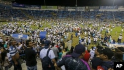 Aficionados irrumpen en el terreno del estadio Cuscatlán en San Salvador, El Salvador, para ayudar a las víctimas de una estampida que dejó 12 muertos y decenas de heridos el 20 de mayo de 2023.