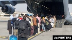 FILE - Evacuees assemble before boarding a C-17 Globemaster III during an evacuation at Hamid Karzai International Airport, Afghanistan, Aug. 18, 2021. (US Marine Corps/Lance Cpl. Nicholas Guevara/Handout via Reuters)