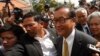 FILE - Sam Rainsy (R), leader of the opposition Cambodia National Rescue Party (CNRP), arrives at the Municipal Court in central Phnom Penh, Jan. 14, 2014. 