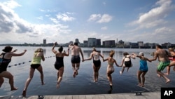 People dive into the Charles River during the "City Splash" event, July 18, 2017, in Boston. 