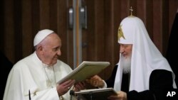 Pope Francis, left, and Russian Orthodox Patriarch Kirill exchange a joint declaration on religious unity at the Jose Marti International airport in Havana, Cuba, Feb. 12, 2016.