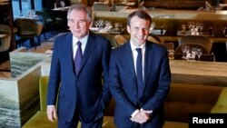 Emmanuel Macron, (R) head of the political movement En Marche !, or Onwards !, candidate for the 2017 presidential election, and Francois Bayrou, French centrist politician and the leader of the Democratic Movement (MoDem), arrive for a news conference after sealing their alliance for the presidential campaign, in Paris, France, Feb. 23, 2017. 