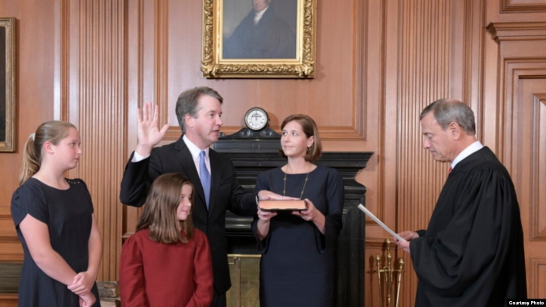 El presidente de la corte de Justicia de EE.UU. John Roberts toma el juramento constitucional a Brett Kavanaugh en Washington, el sábado 6 de octubre de 2018.lLa esposa de Kavanaugh, Ashley, sostiene la Biblia y las dos hijas de la pareja observan la ceremonia. (F. Schilling/Collection of the Supreme Court of the United States)