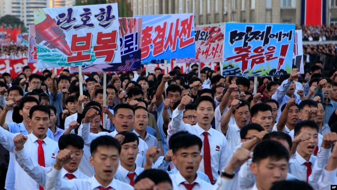 Severnokorejci okupili su se na Trgu Kim Il Sunga na velikom mitingu protiv Amerike, 23. septembra 2017. u Pjongjangu, Severna Koreja, dan nakon što je lider zemlje izdao retko viđeno saopšenje u kome napada predsednika SAD Donalda Trampa. Na transparentu koji nosi demonstrant levo piše "Odlučna osveta," a u rukama desnog piše "Smrt američkim imperijalistima".