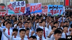 North Koreans gather at Kim Il Sung Square for a mass rally against America, Sept. 23, 2017, in Pyongyang, North Korea, a day after the country's leader issued a rare statement attacking Donald Trump. The sign on the left reads "decisive revenge" and the sign on the right reads "death to the American imperialists." 