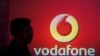 FILE PHOTO: A man casts silhouette onto an electronic screen displaying logo of Vodafone India after a news conference in Mumbai, India, Nov. 10, 2015. 