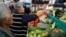 A woman buys tomatoes in a groceries stall at Granada market in Mexico City, Mexico, Jan. 10, 2017. 