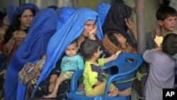 An Afghan woman sits amidst her children as they wait to be repatriated to Afghanistan from a United Nations Humanitarian Commission for Refugees (UNHCR) registration center in Peshawar, Pakistan, Jun 20, 2010 (file photo)