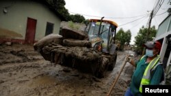 Una máquina retira colchones cubiertos de barro en un área dañada por las inundaciones debido a las lluvias traídas por los huracanes Eta e Iota, en La Lima, Honduras el 7 de diciembre de 2020.