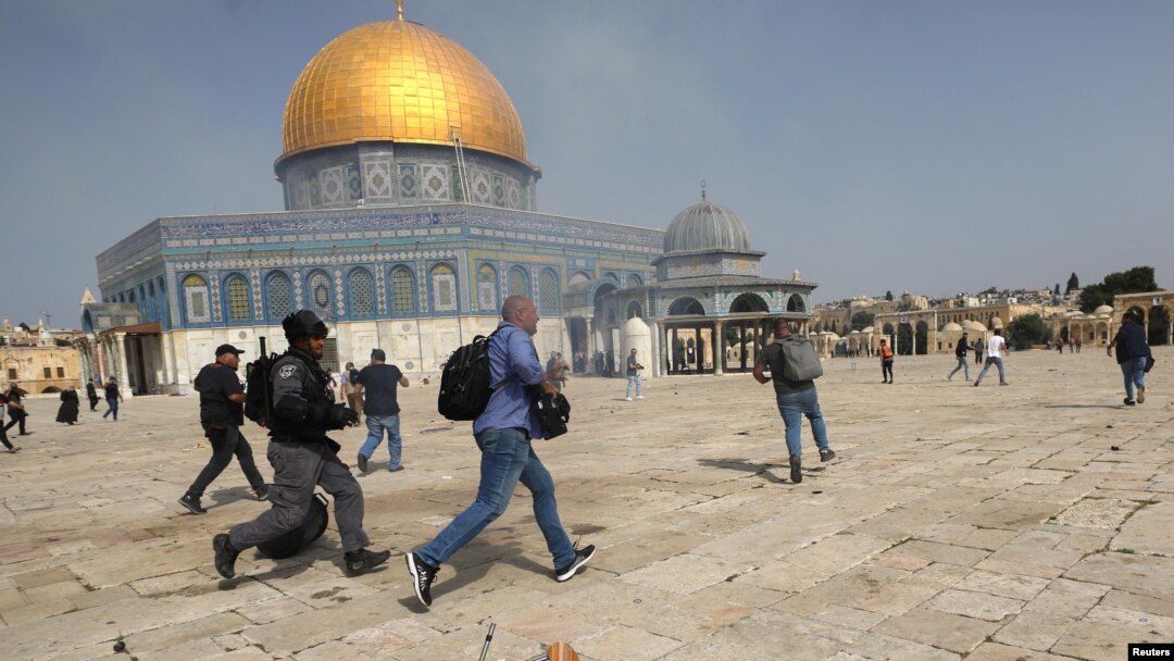 Pripadnik izraelske policije trči za snimateljem tijekom sukoba s Palestincima u kompleksu u kojem se nalazi džamija Al-Aqsa, koja je muslimanima poznata kao Plemenito utočište, a Židovima kao Hramska planina, u starom gradu Jeruzalema, 10. maja 2021. REUTERS / Ammar Awad