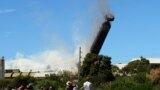 A 200-meter-high chimney, built from about 7,000 tonnes of concrete, bricks and steel, is brought down in a controlled explosion at Port Kembla, south of Sydney, Australia. Nearly 1,000 explosives charges were placed around the copper stack, which broke into at least two pieces just before hitting the ground as thousands of people gathered to watch the explosion.