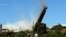 A 200-meter-high chimney, built from about 7,000 tonnes of concrete, bricks and steel, is brought down in a controlled explosion at Port Kembla, south of Sydney, Australia. Nearly 1,000 explosives charges were placed around the copper stack, which broke into at least two pieces just before hitting the ground as thousands of people gathered to watch the explosion.