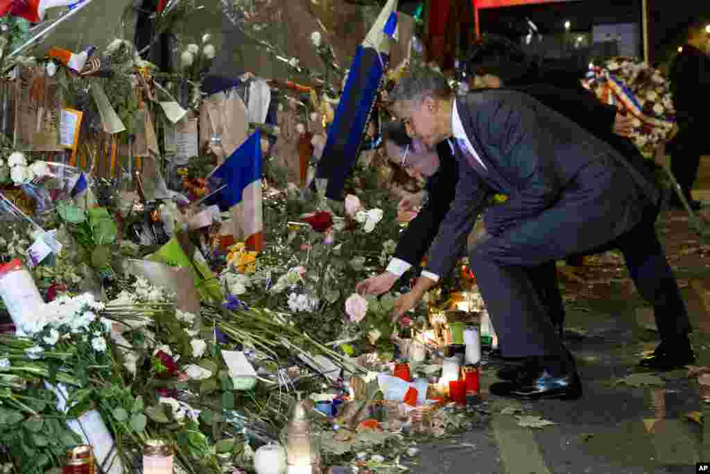 President Barack Obama, right, and French President Francois Hollande place flowers at the Bataclan, site of one of the Paris terrorists attacks, to pay respects after arriving in town for the COP21 climate change conference in Paris.