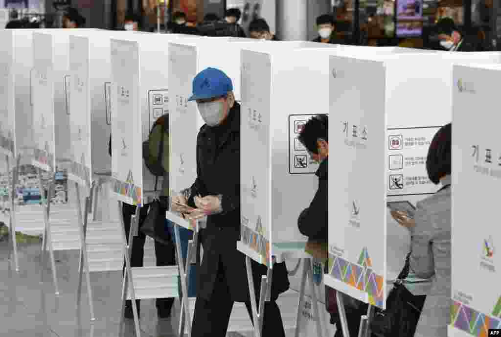 A South Korean man casts a ballot during early voting ahead of next week&#39;s parliamentary elections, at a polling station in Seoul. 