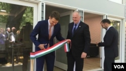 Ambassador László Szabó, center, looks on as Hungarian State Secretary for Economic Strategy László György, left, cuts a ribbon at the opening ceremony of a business promotion center in Washington, June 12, 2019. (Natalie Liu/VOA)