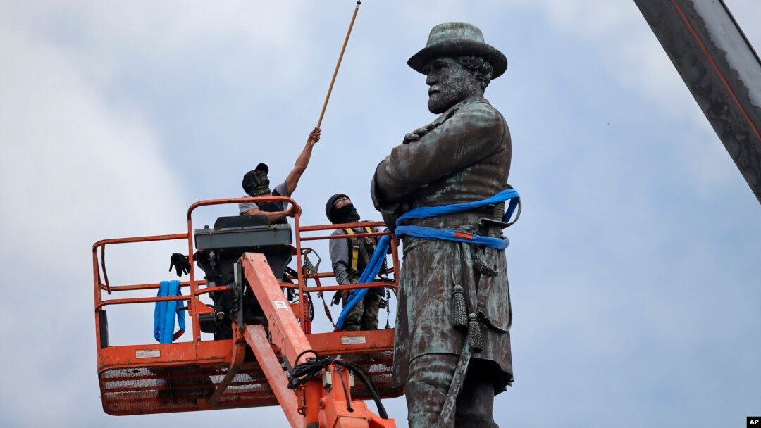 FILE - Workers prepare to take down the statue of former Confederate general Robert E. Lee in New Orleans, May 19, 2017.