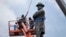 FILE - Workers prepare to take down the statue of former Confederate general Robert E. Lee in New Orleans, May 19, 2017.