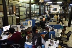 FILE - Journalists work in the newsroom of privately owned Myanmar Times newspaper in Yangon, Oct. 11, 2018.