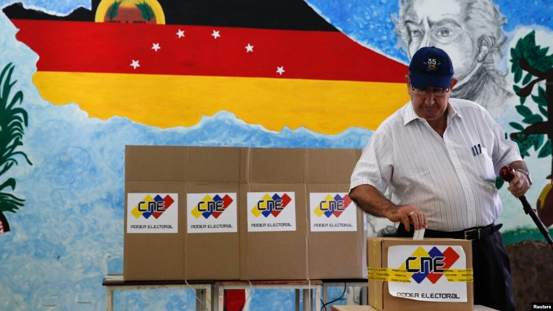 A man casts his ballot in a box during a municipal elections in Caracas, Venezuela, Dec. 8, 2013. 