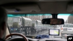 Cette photo prise par la mission de surveillance de l'OSCE dans la ville de Louhansk, dans l'est de l'Ukraine, montre des véhicules blindés et des hommes armés circulant dans le centre-ville, le 21 novembre 2017.