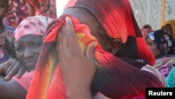 FILE - Women from the city of Al-Junina (West Darfur) cry after receiving the news about the death of their relatives as they waited for them in Chad, November 7, 2023. 