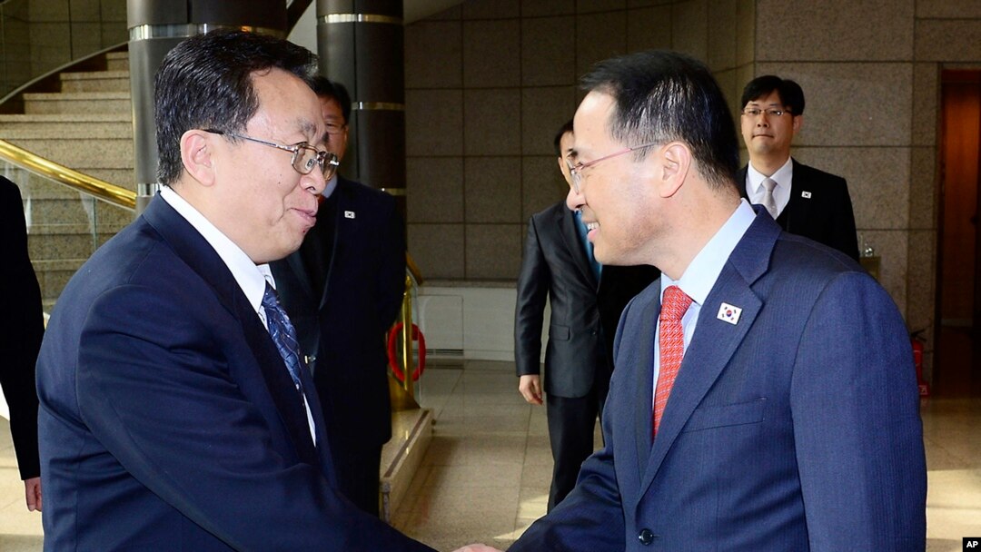 韩国代表团团长金奎显（右）在板门店与朝鲜代表团团长元东渊握手。（2012年2月12日）
