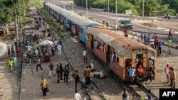 Des usagers marchent près d'un train à Kinshasa, le 3 avril 2017.