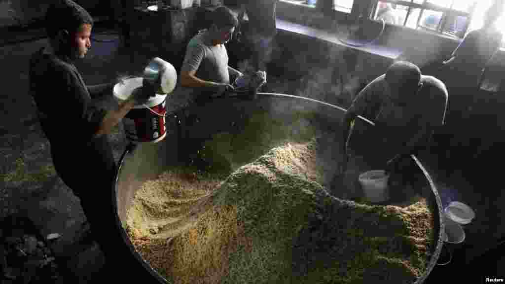Workers prepare food for distribution to residents and those displaced in the city of Raqqa, Syria.