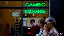 FILE - Pedestrians walk past a money exchange shop in Buenos Aires, Argentina, Oct. 10, 2023. 
