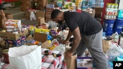 FILE - N.C. State defensive end Davin Vann works among the donations collected to help Hurricane Helene victims in western North Carolina, Wednesday, Oct. 2, 2024 in Raleigh, N.C. (AP Photo/Aaron Beard)