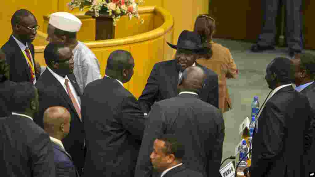 Poignée des mains entre le leader des rebelles Riek Machar, centre-gauche, dos tourné à la camera et le président sud-soudanais, Salva Kiir, centre-droite, au cours des négociations à Addis Abeba, Ethiopie, 17 aout 2015. (AP Photo/Mulugeta Ayene)