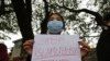 FILE- A woman holds a placard during a protest against the killing of a Muslim man on Sept. 28 in Belagavi district of the southern Indian state of Karnataka, in Bengaluru, India, Tuesday, Oct. 5, 2021. 