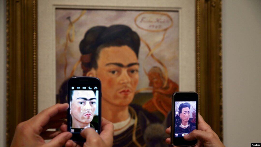 El público fotografía "Autoretrato con mono", de la artista mexicana Frida Kahlo (1907-1954) durante la exhibición 'Frida Kahlo/Diego Rivera, Art in Fusion' en el Musee de l'Orangerie, París, 7-10-13.