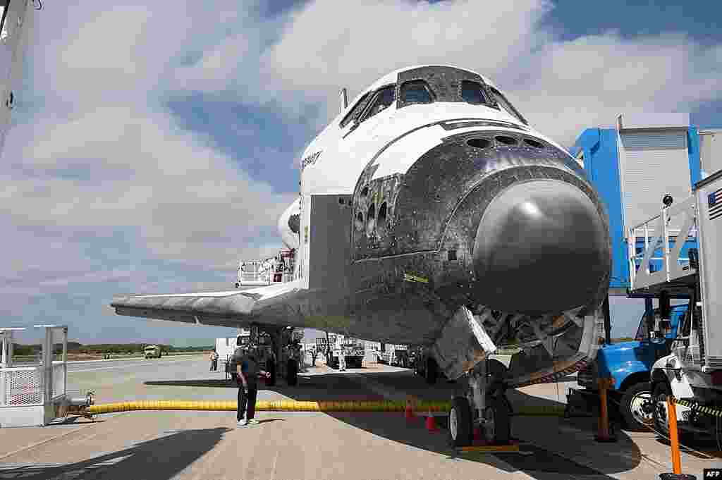 The landing convoy that will make space shuttle Discovery secure for towing to its processing hangar begins to pull up around the spacecraft at Kennedy Space Center in Florida, March 9, 2011. (NASA) 
