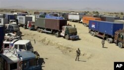 Pakistani border guards stand alert at a terminal of Afghanistan-bound NATO trucks parked at Pakistani border post of Chaman along Afghanistan on Wednesday, Oct. 6, 2010.