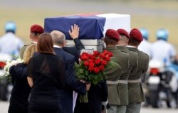 FILE - Relatives of three Czech soldiers, who were killed by a suicide bomber in eastern Afghanistan, mourn at the Vaclav Havel Airport in Prague, Czech Republic, Aug. 8, 2018.