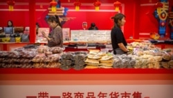 Clerks stand at a display of goods at a "Belt and Road Products New Year's Marketplace" at a shopping mall in Beijing, Jan. 10, 2020. The market showcases products created from countries and regions involved in China's Belt and Road Initiative.