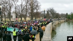 Activistas en pro de los derechos civiles marchan en honor del reverendo Martin Luther King Jr. el sábado 14 de enero de 2017 en Washington. 