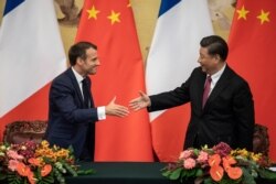 French President Emmanuel Macron, left, shakes hands with Chinese President Xi Jinping following a signing ceremony at the Great Hall of the People in Beijing, Nov. 6, 2019.