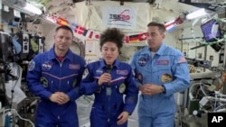 In this image from video made available by NASA, U.S. astronaut Jessica Meir speaks, accompanied by Andrew Morgan and Chris Cassidy, during a news conference held by the American members of the International Space Station on April 10, 2020.