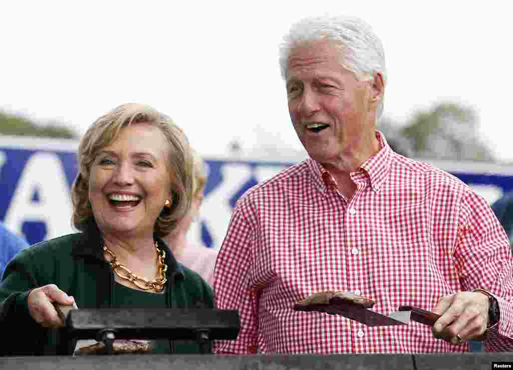 Former U.S. Secretary of State Hillary Clinton and her husband former President Bill Clinton hold up some steaks at the 37th Harkin Steak Fry in Indianola, Iowa, Sept. 14, 2014.