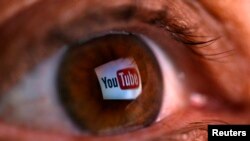 FILE - A reflection of YouTube's logo is seen in a person's eye.