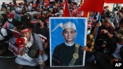 FILE - An image of deposed Myanmar President Win Myint is displayed at an anti-coup rally in Yangon, Myanmar, Feb. 20, 2021. 